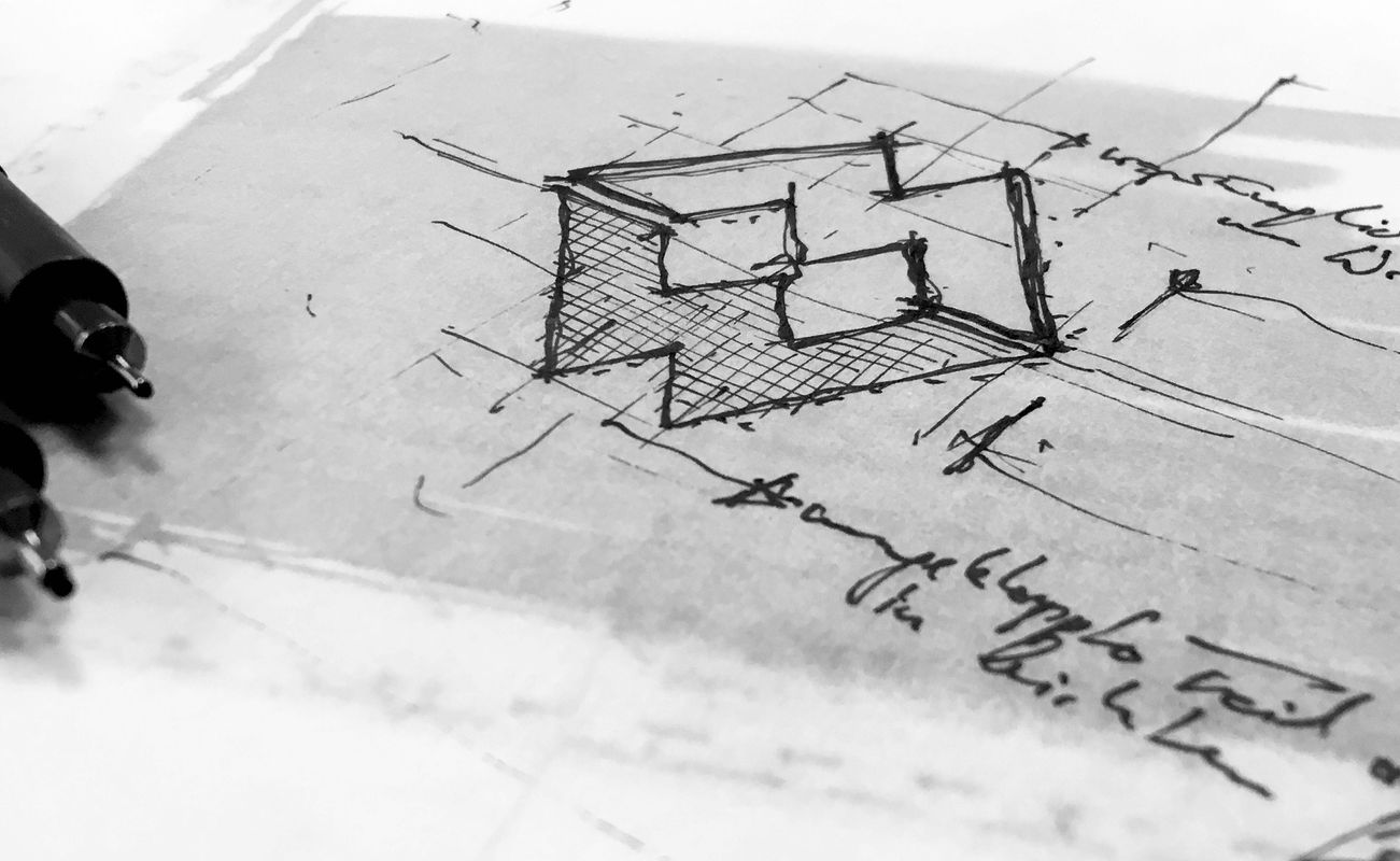 Skizze eines dreidimensionalen Objekts mit Bleistift und zwei schwarzen Stiften daneben. Technische Zeichnungen und Notizen sind sichtbar.